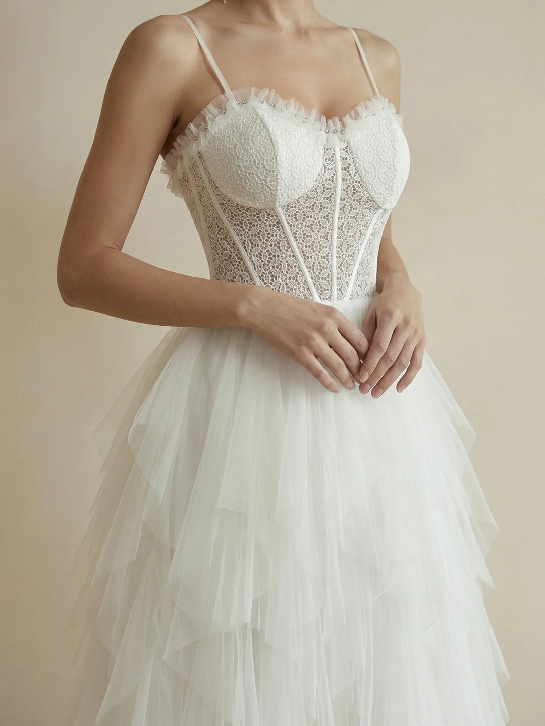 White corset-style lace bodice bridal gown with layered tulle skirt and thin straps