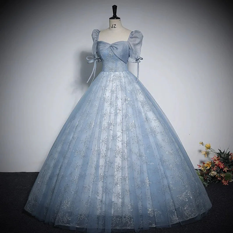 Light blue shiny ball gown with puff sleeves, bow ties, and sparkly tulle skirt