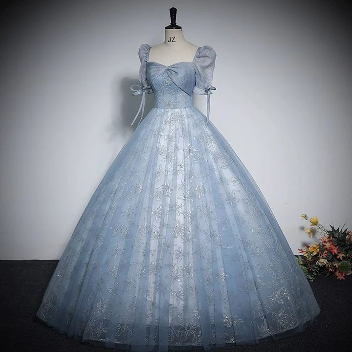 Light blue shiny ball gown with puff sleeves, bow ties, and sparkly tulle skirt