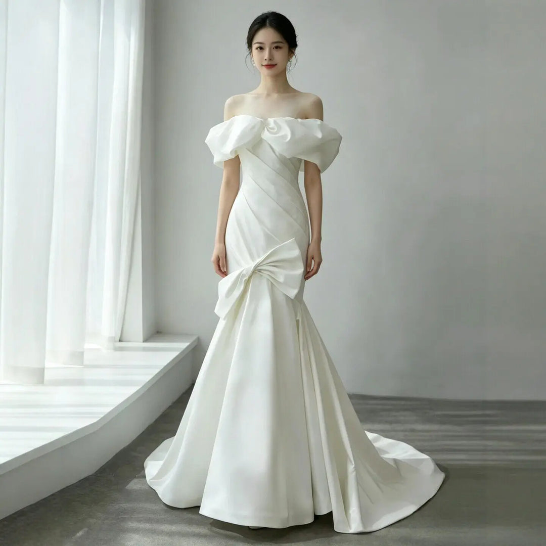 White satin off-shoulder wedding ball gown with ruffled neckline and voluminous skirt