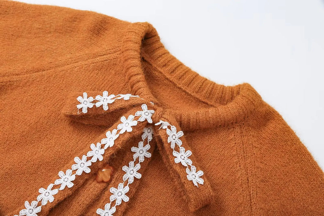 Orange knit cardigan neckline with white lace applique ribbon detail