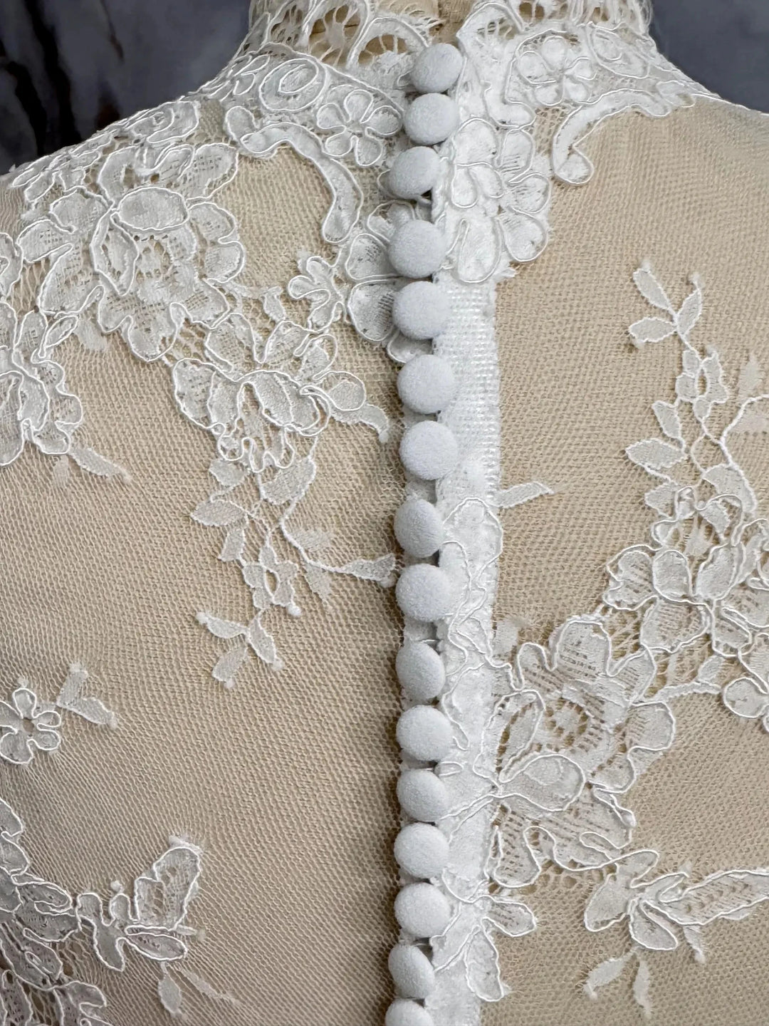 Off-white lace high-neck jacket bodice with floral embroidery and pompom trim