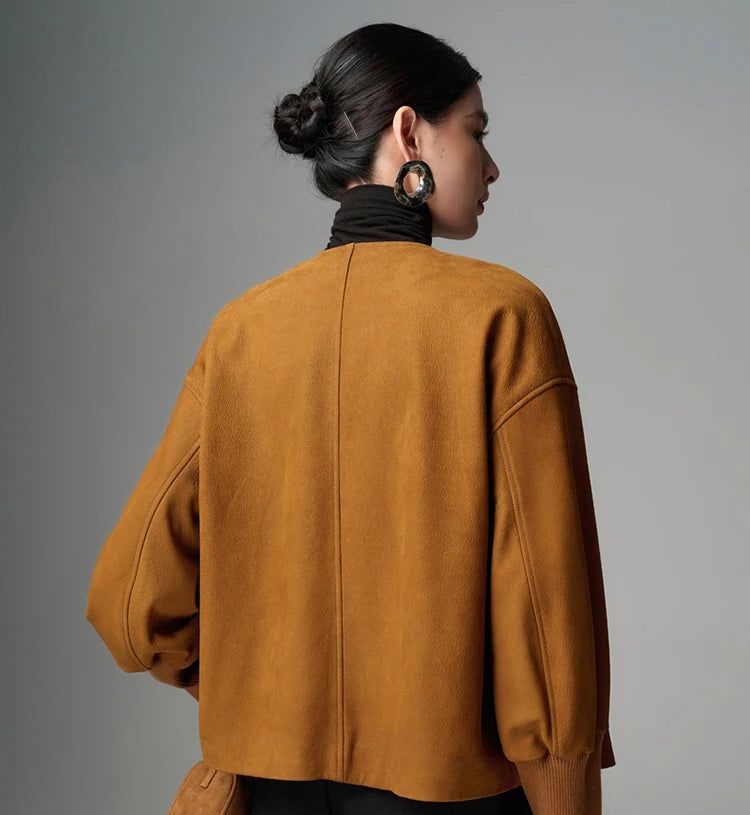 Back view of mustard-brown shearling leather jacket with center seam and sleeve seams