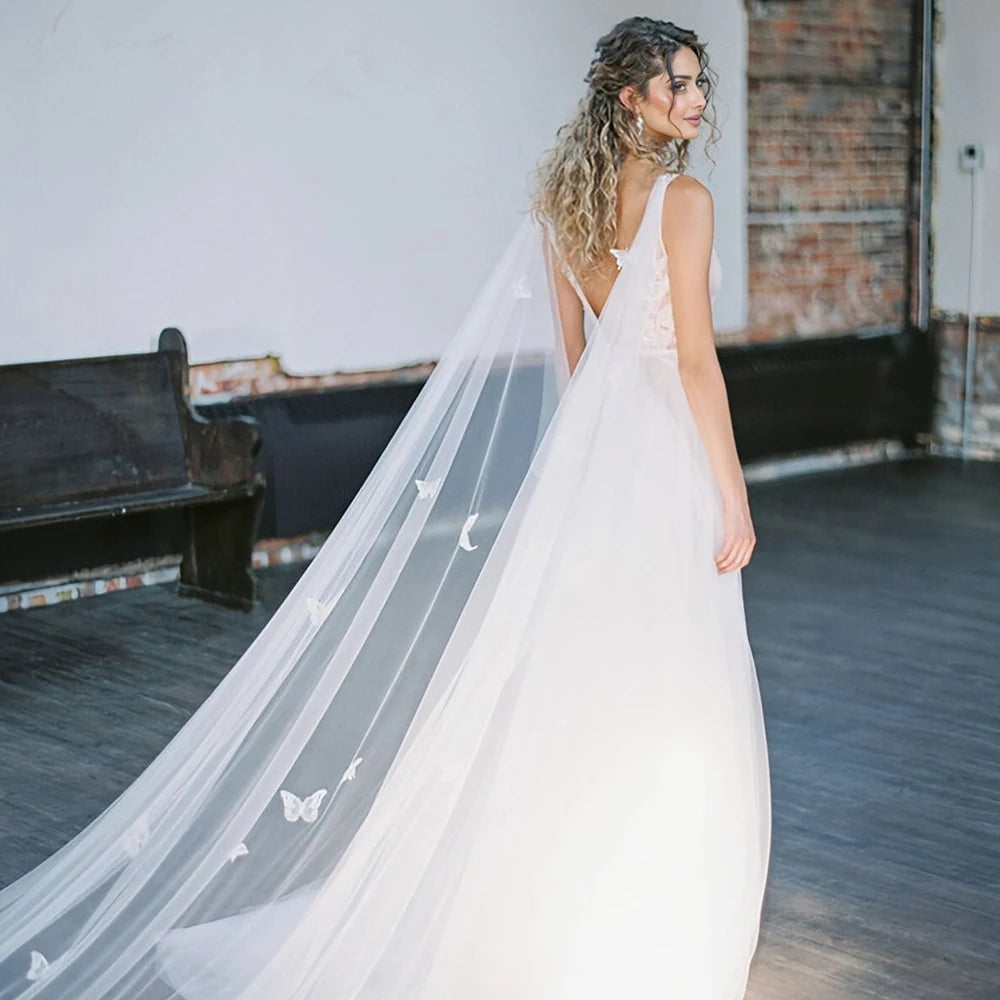 White bridal cape with sheer tulle panels and scattered 3D butterfly appliques
