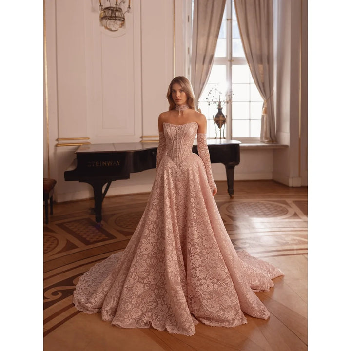 Light pink embroidered lace prom gown with structured bodice and tiered full skirt