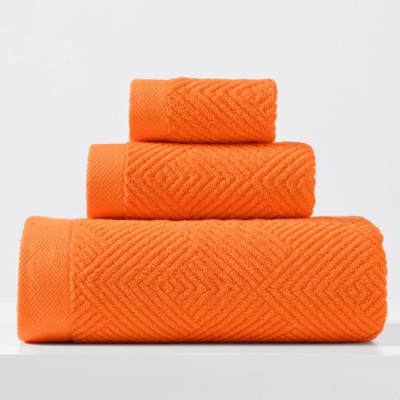 Bright orange cotton towel set with thick chevron weave, stacked folded towels