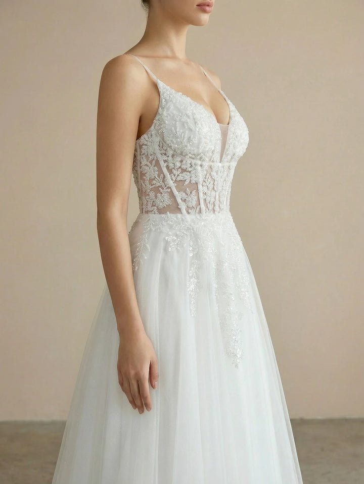 White lace bridal ball gown with spaghetti straps, sheer bodice, and tulle skirt