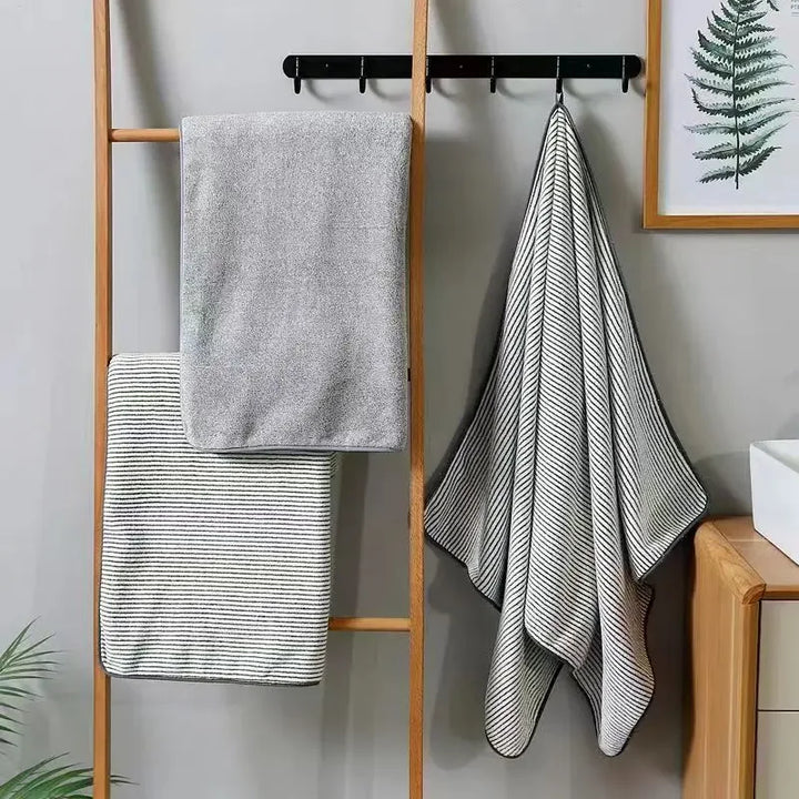 Towel set on a ladder: striped face towels and a light gray hand towel