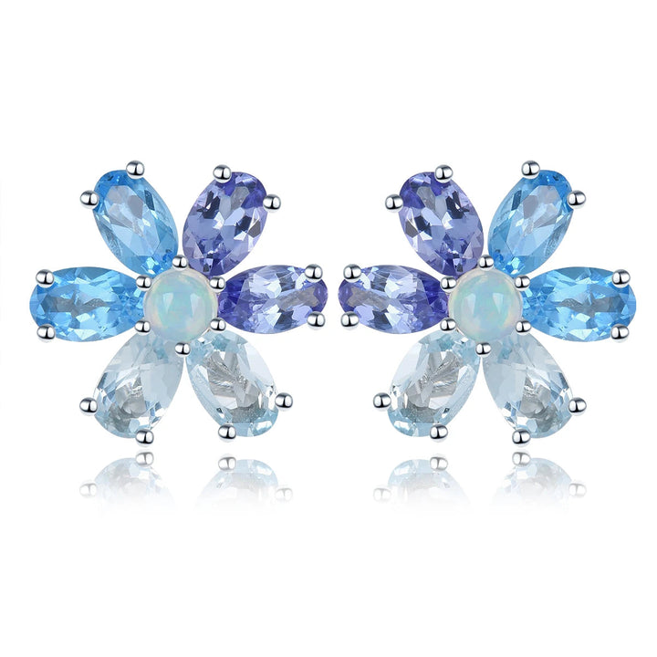 Pair of flower-shaped earrings with blue and purple gemstones on a white background