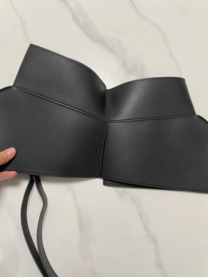 Wide black waist belt with centered curved cutout and tied ends