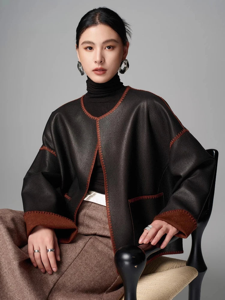 Women’s black goatskin short jacket with brown cuffs, V-front placket, orange topstitching