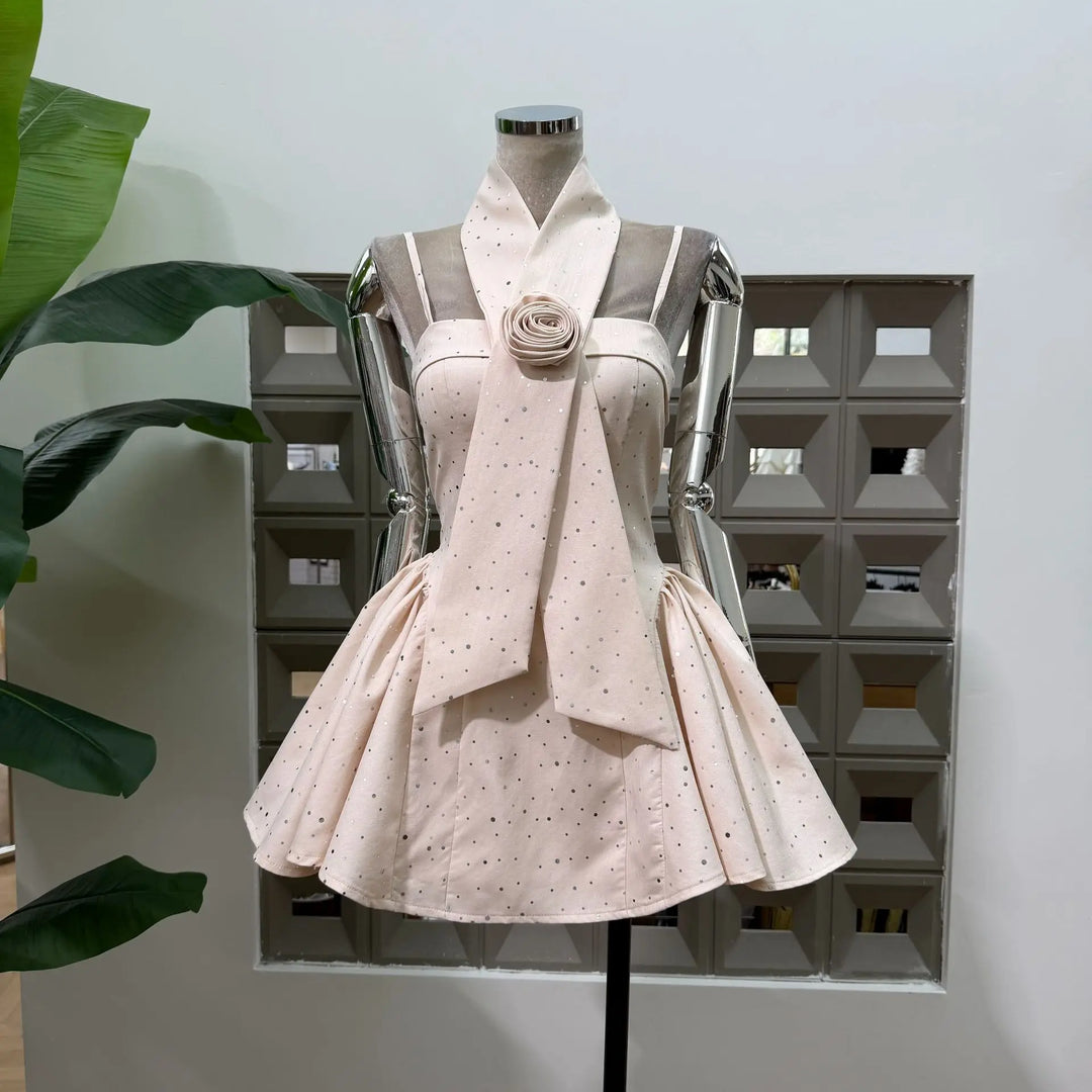 Beige polka dot mini dress with spaghetti straps and rosette waist detail