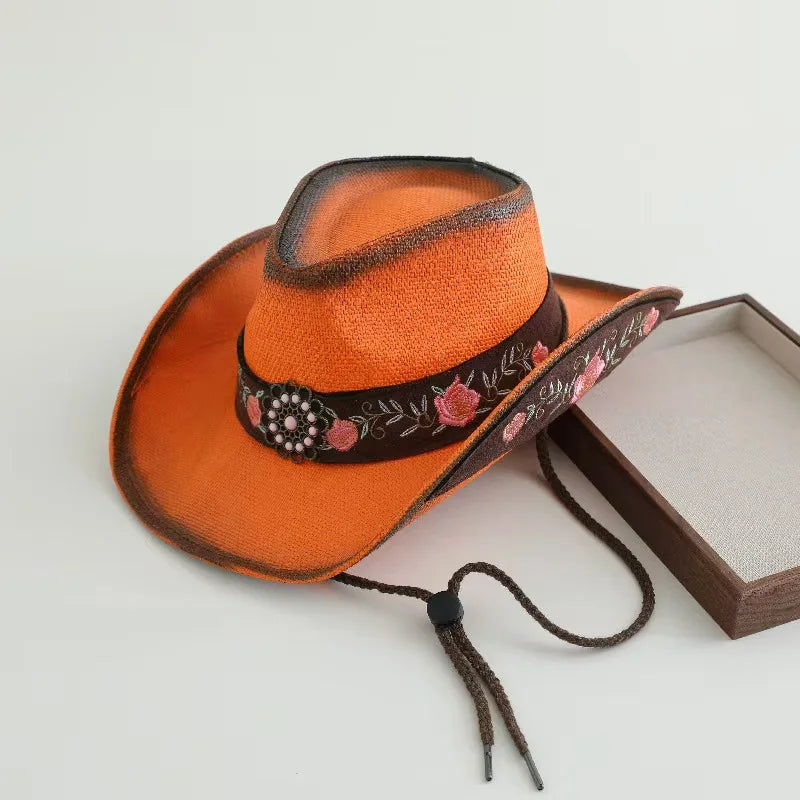 Orange cowboy hat with dark decorative band and braided cord chin ties