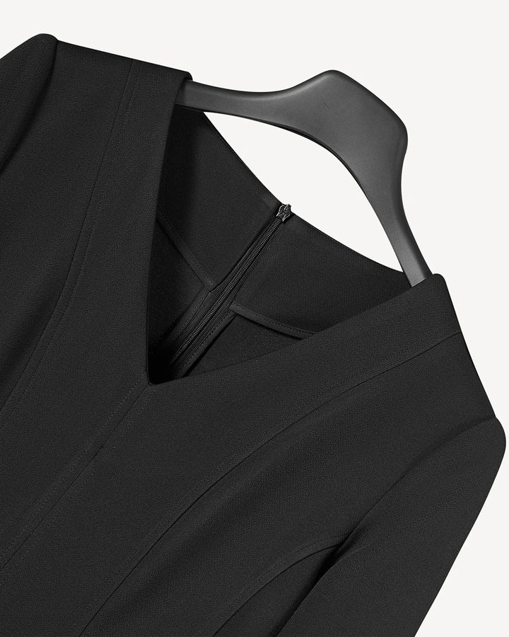 Black V-neck dress close-up showing fitted bodice and front seam detail