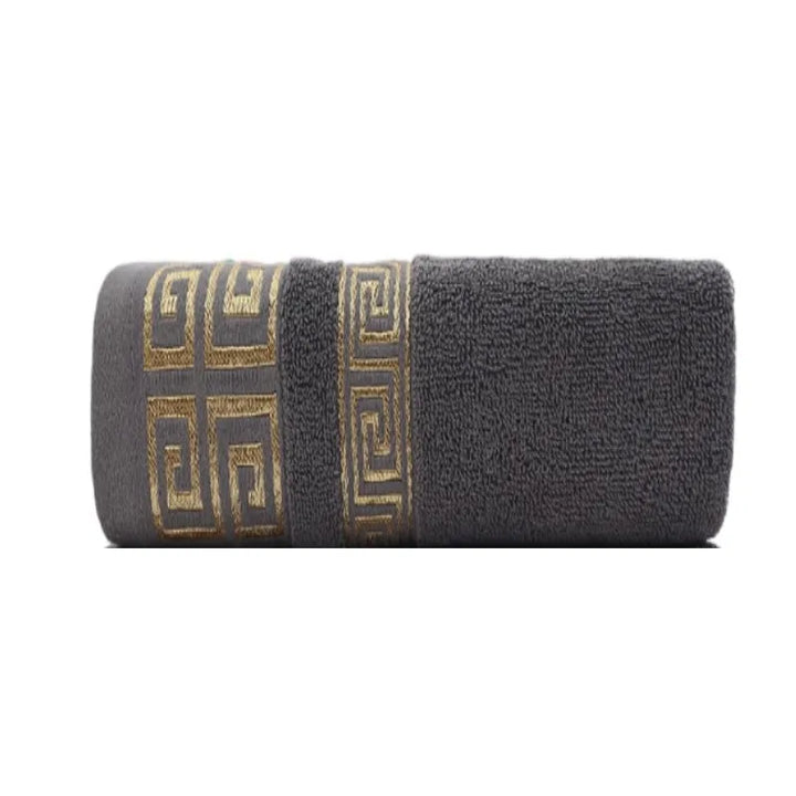 Cotton bathroom towel set in dark gray with gold Greek border, rolled.