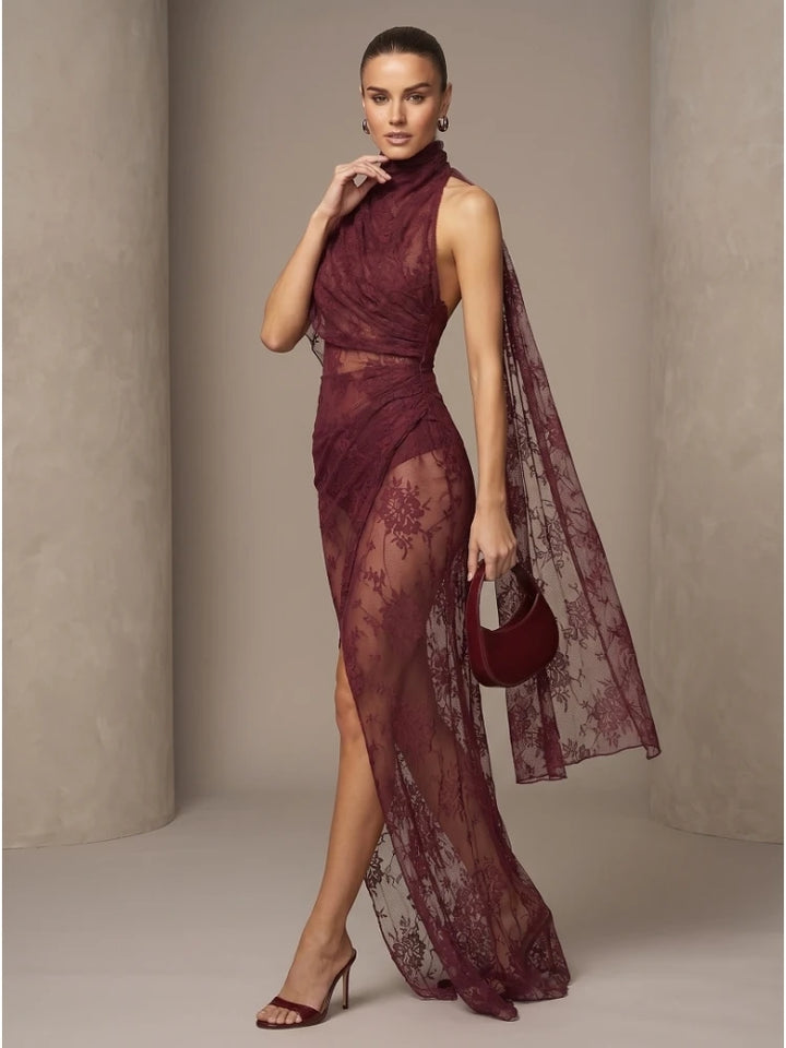 Burgundy sheer lace maxi gown with high neck, fitted bodice, sheer cape overlay, slit.