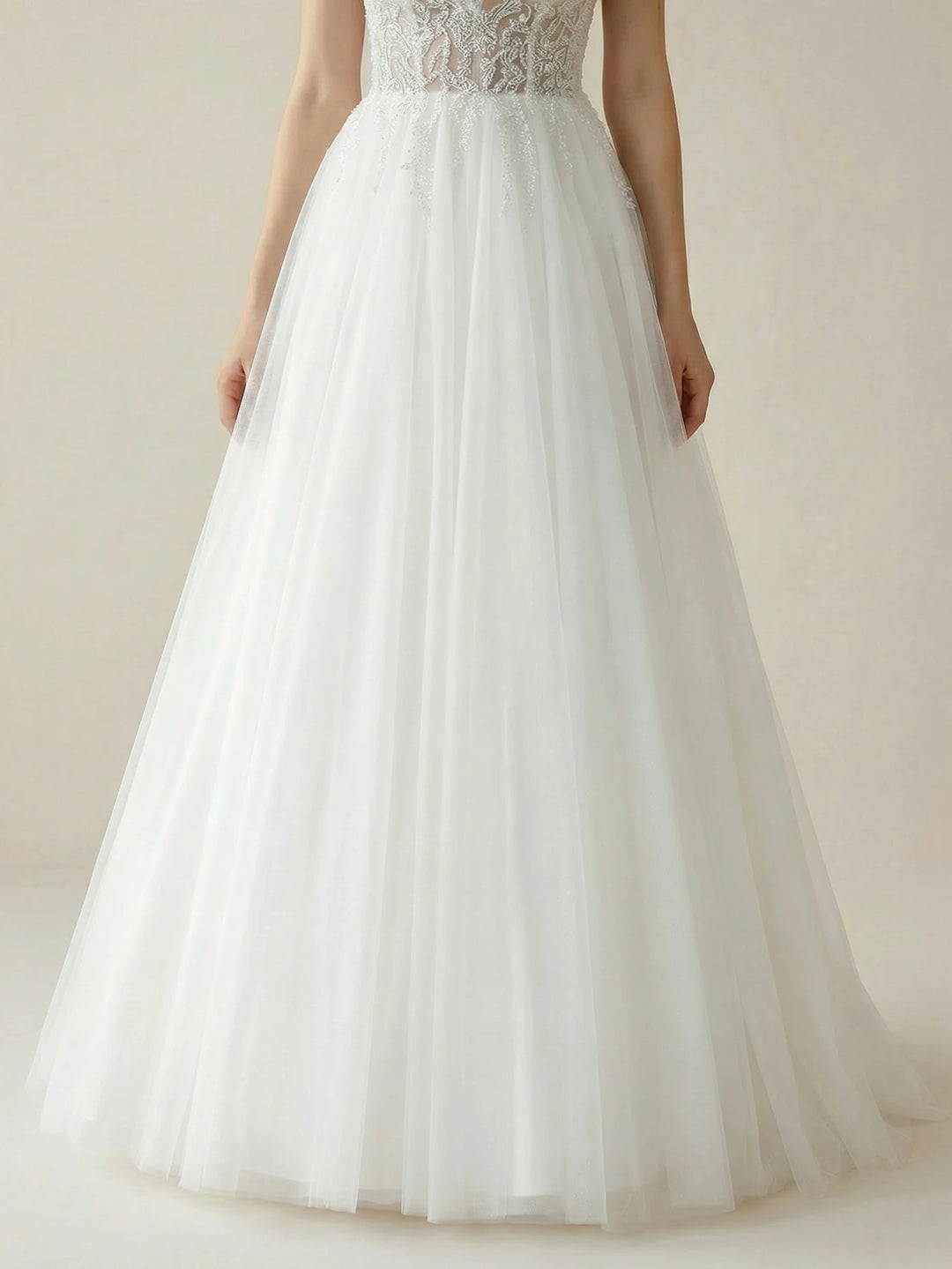 White A-line bridal gown with textured lace bodice and flowing tiered tulle skirt