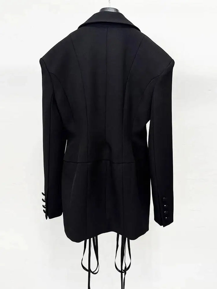 Black women’s lapel blazer, back view with shoulder seams and fringe cords at hem