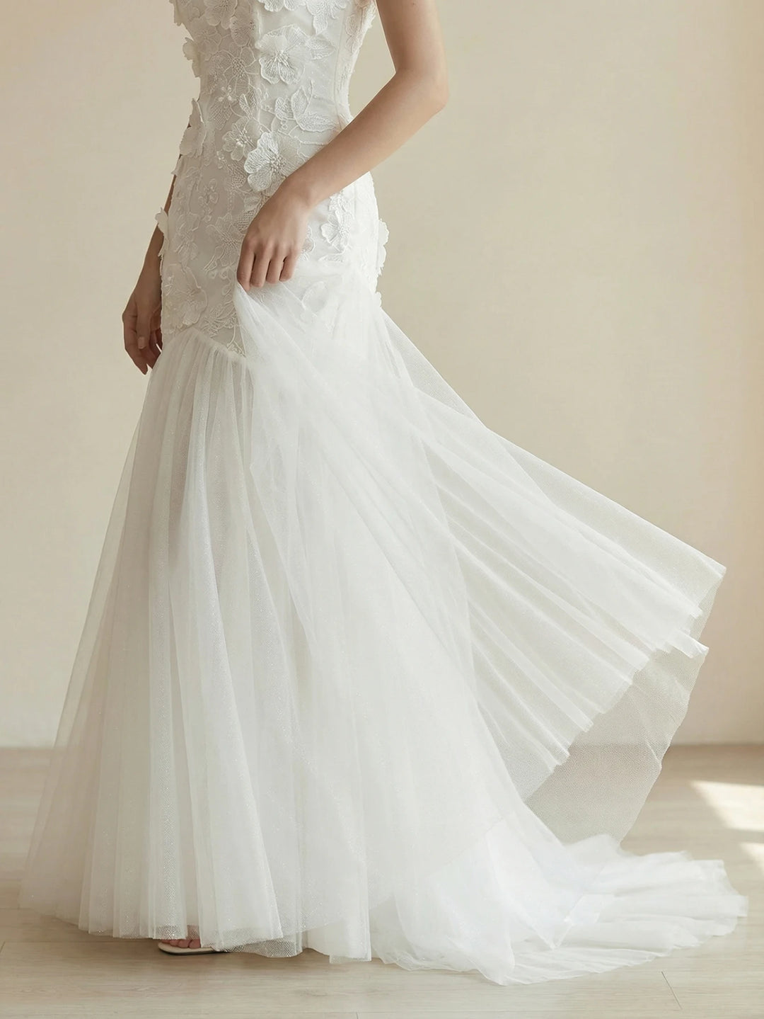 White appliqué bridal gown with fitted bodice and flowing tulle skirt with train