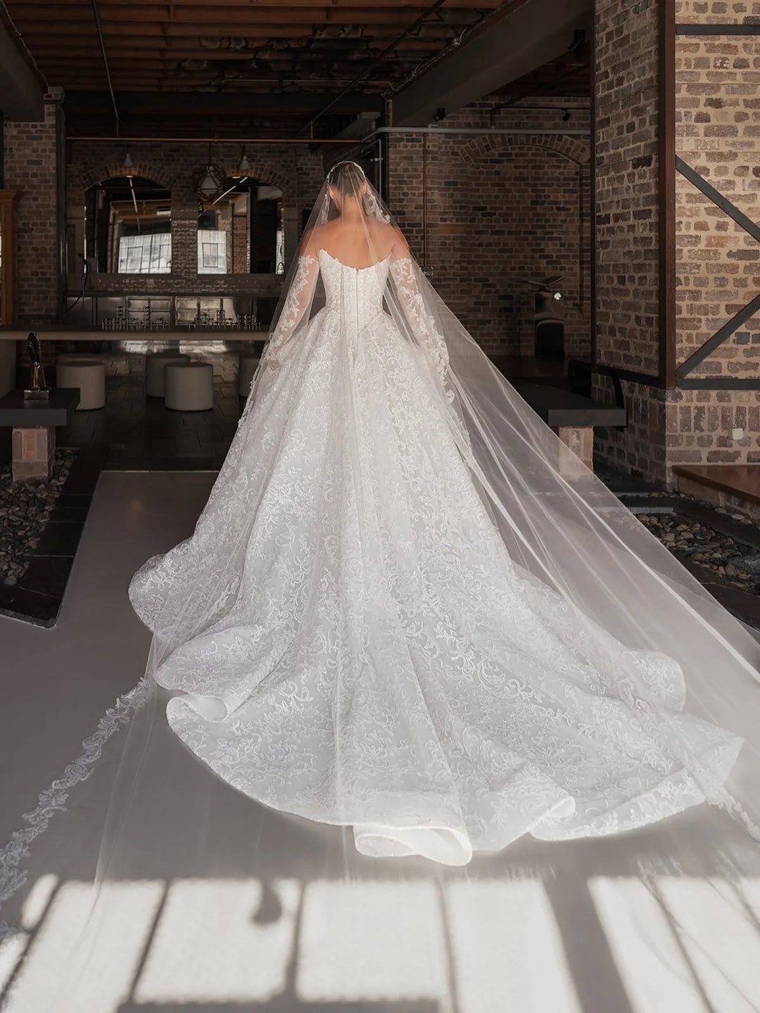 White bridal lace gown back view with long tulle veil and high slit opening