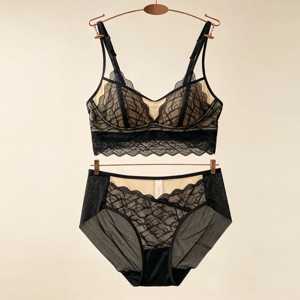 Black lace lingerie bra and matching high-rise panties set on hangers