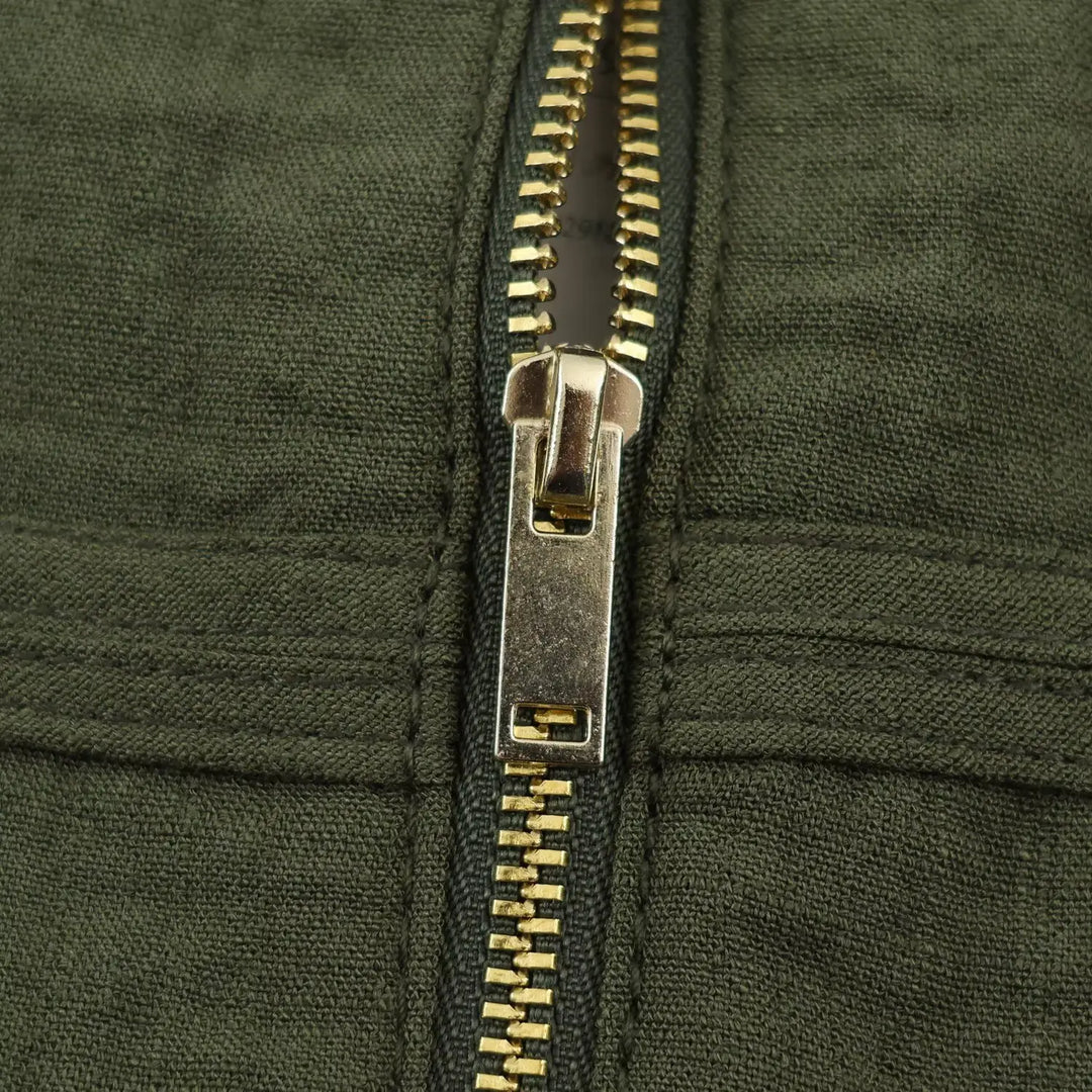 Green waistcoat top close-up: gold zipper with snap-placket style