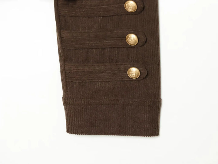 Brown coat sleeve cuff with three gold buttons and stitched horizontal details