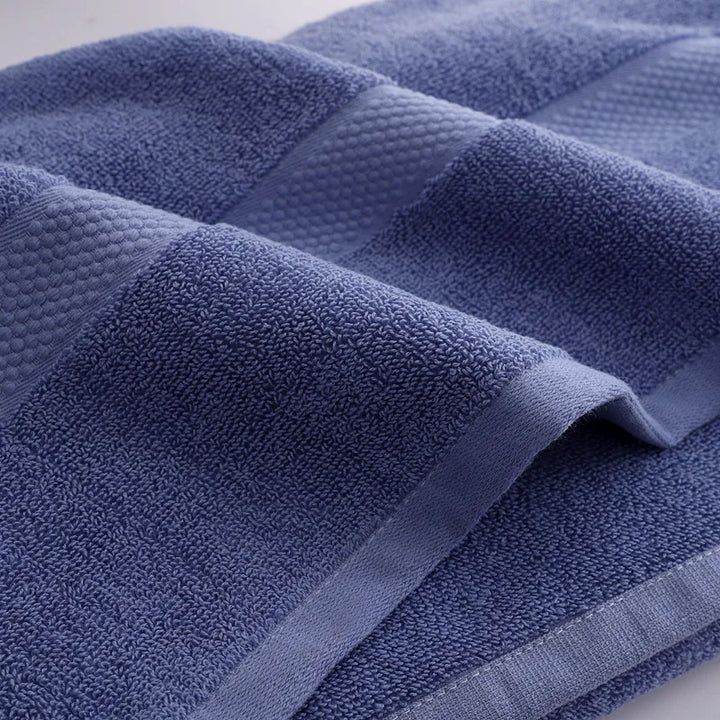 Blue bath towel close-up showing ribbed border and textured terry surface