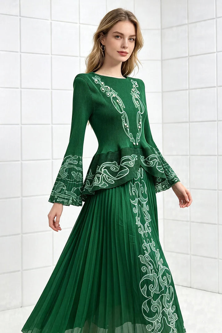 Green two-piece pleated skirt set with long sleeves and ornate embroidered pattern