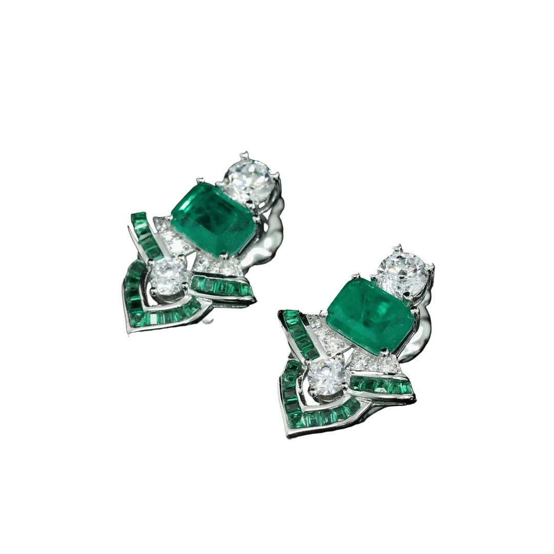 Pair of emerald and diamond earrings on a black background