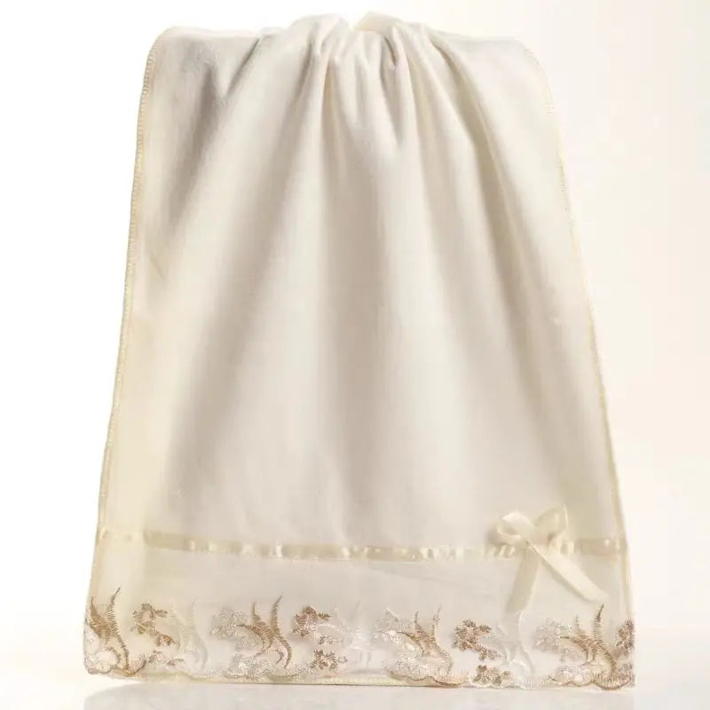 Cream microfiber towels with lace hem, in a gathered drawstring storage bag