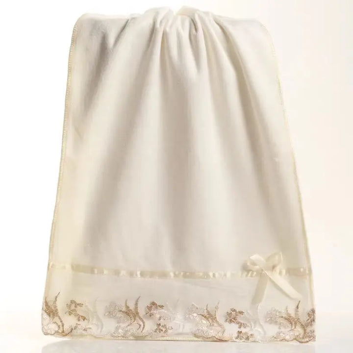 Cream microfiber towels with lace hem, in a gathered drawstring storage bag
