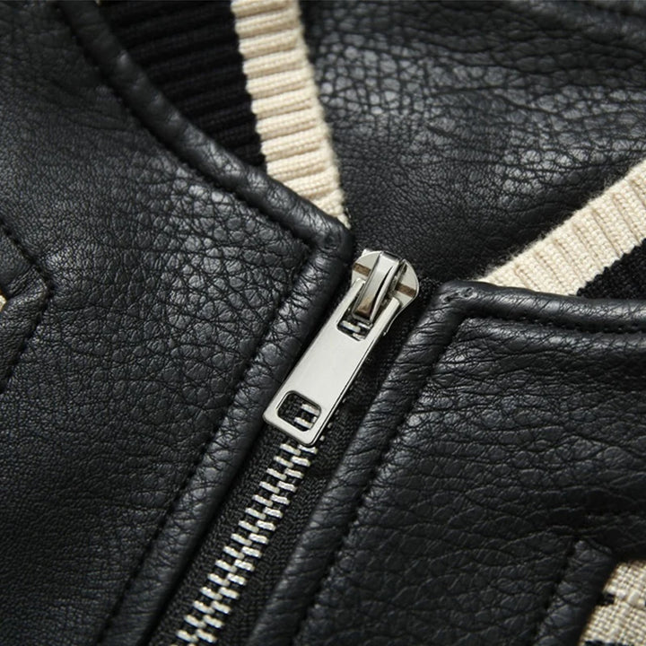 Close-up of front zipper on black leather baseball coat with ribbed knit collar trim