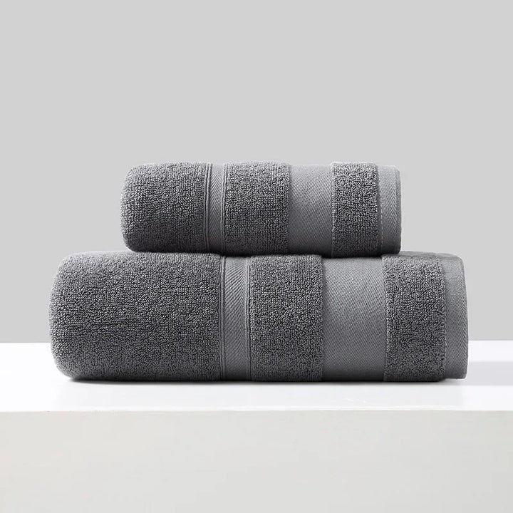 2-piece cotton towel set in dark gray, rolled and folded with stitched bands