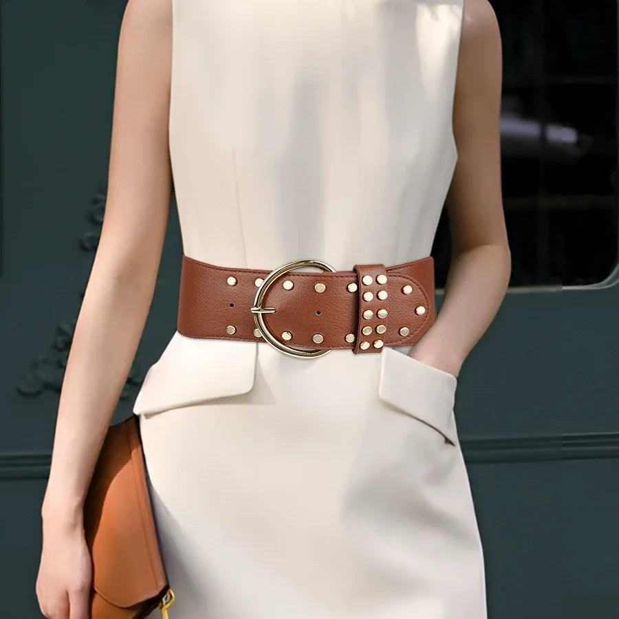 Camel brown women's elastic belt with round gold buckle and rivet strap loops.